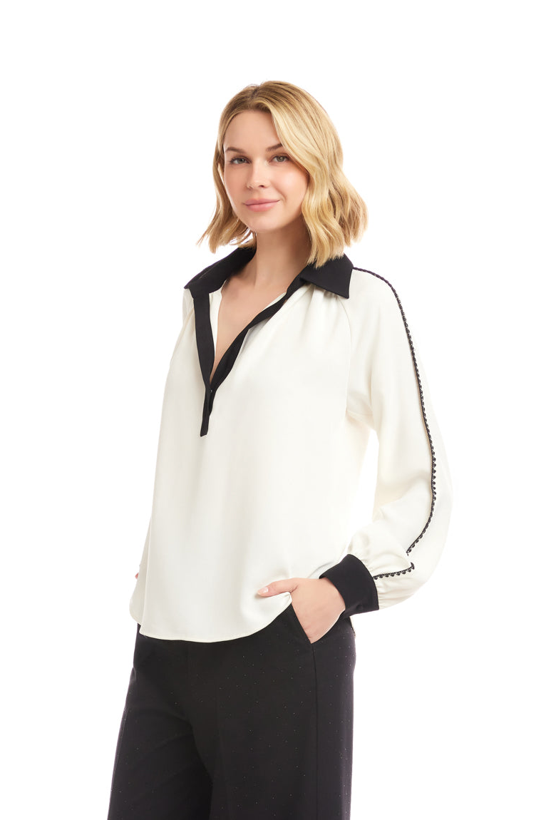 Woman wearing a white blouse with black accents on a white background