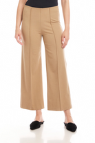 Person wearing beige wide-leg pants on a white background