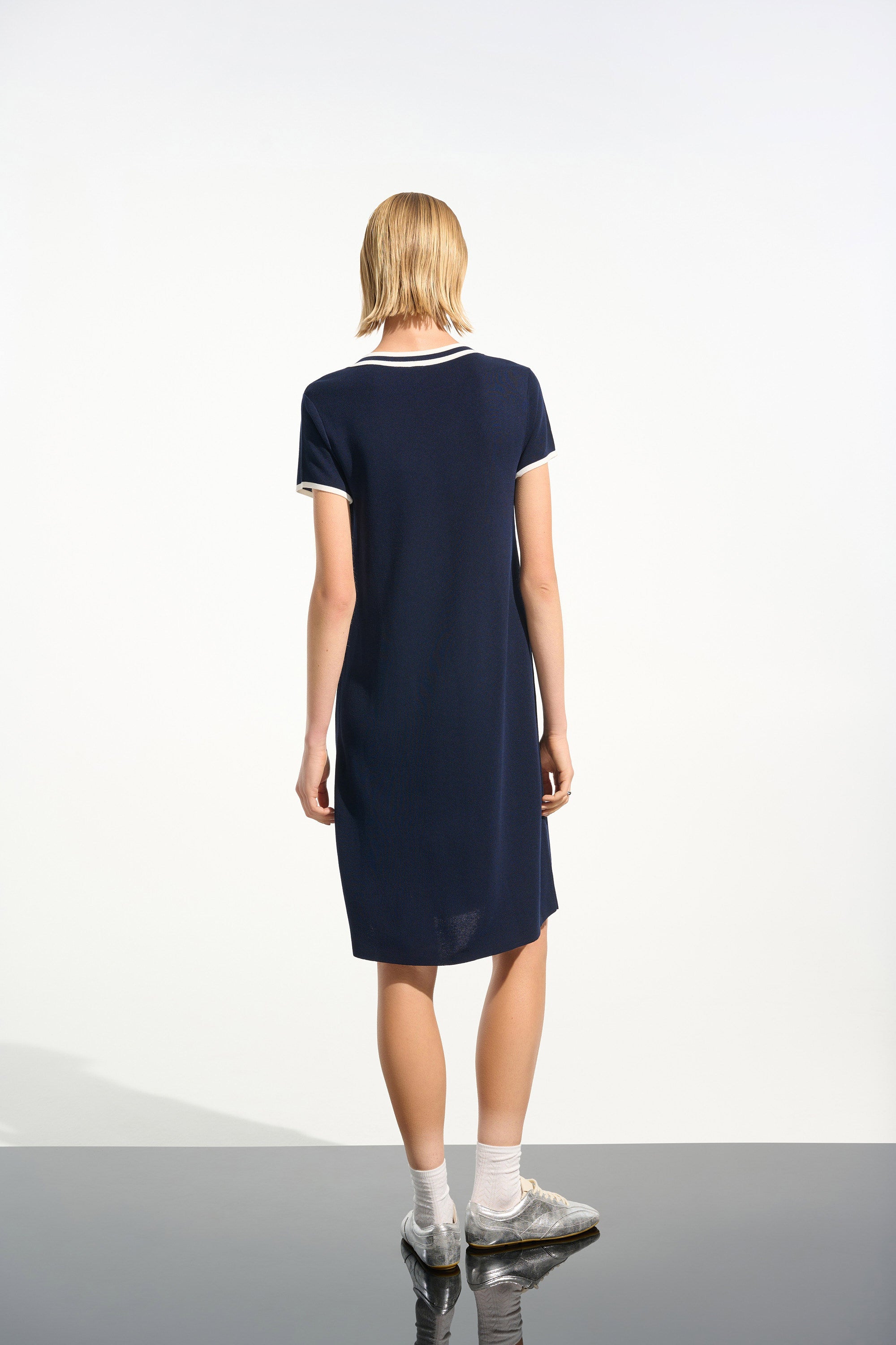 Woman wearing a navy blue dress on a white background