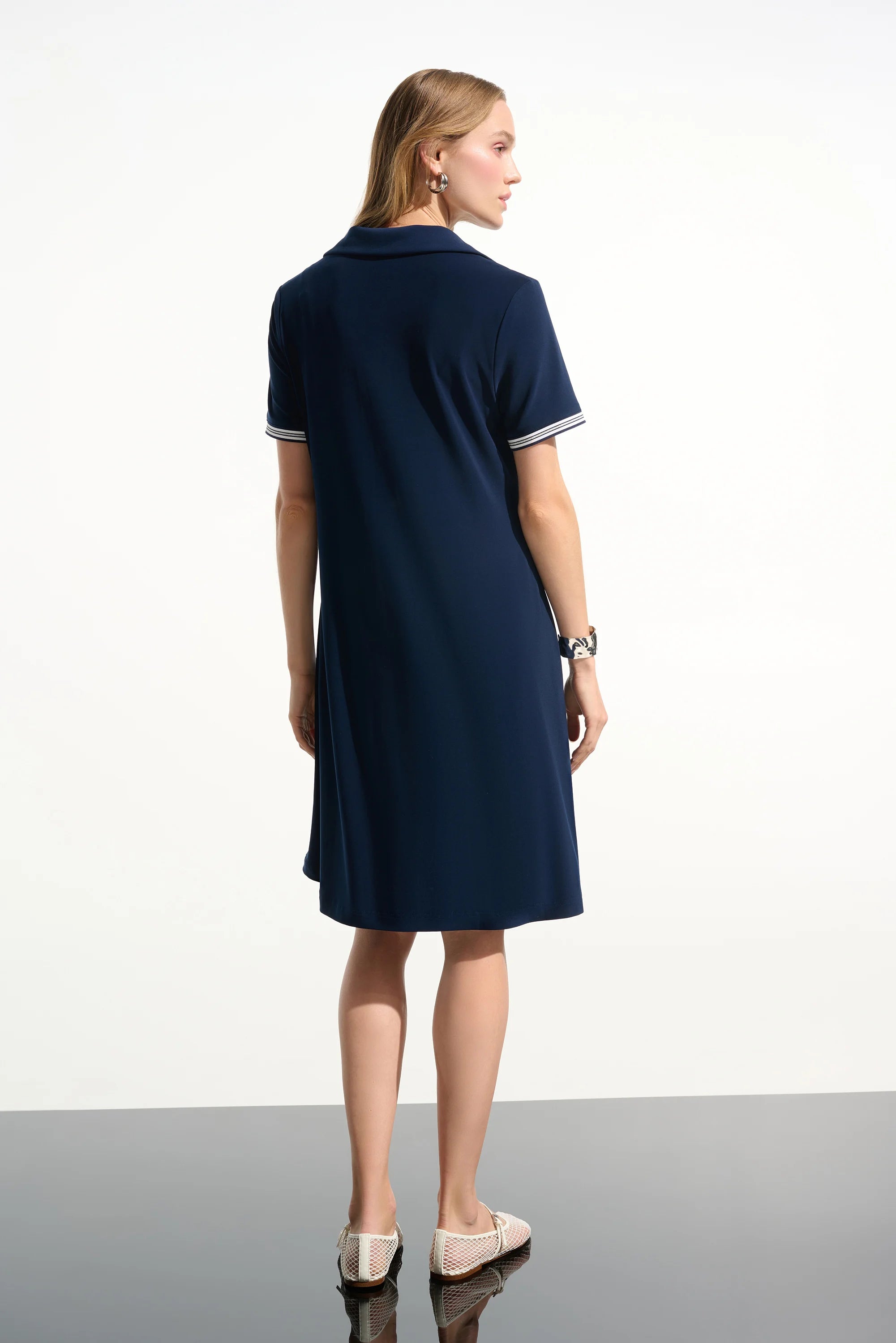 Woman wearing a navy dress on a white background