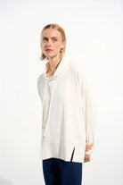 Woman wearing a white blouse and blue pants on a white background
