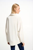 Woman wearing a white blouse with long sleeves on a white background