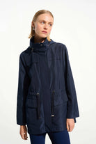 Woman wearing a navy blue raincoat on a white background