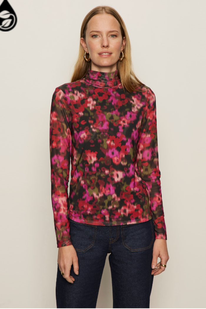 Woman wearing a floral long-sleeve top against a plain background
