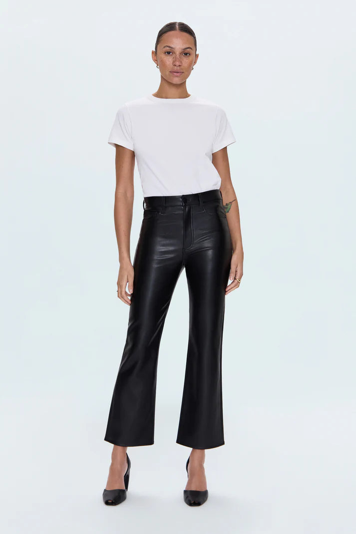 Person wearing a white t-shirt and black leather pants on a light blue background