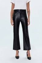 Person wearing black leather pants on a white background