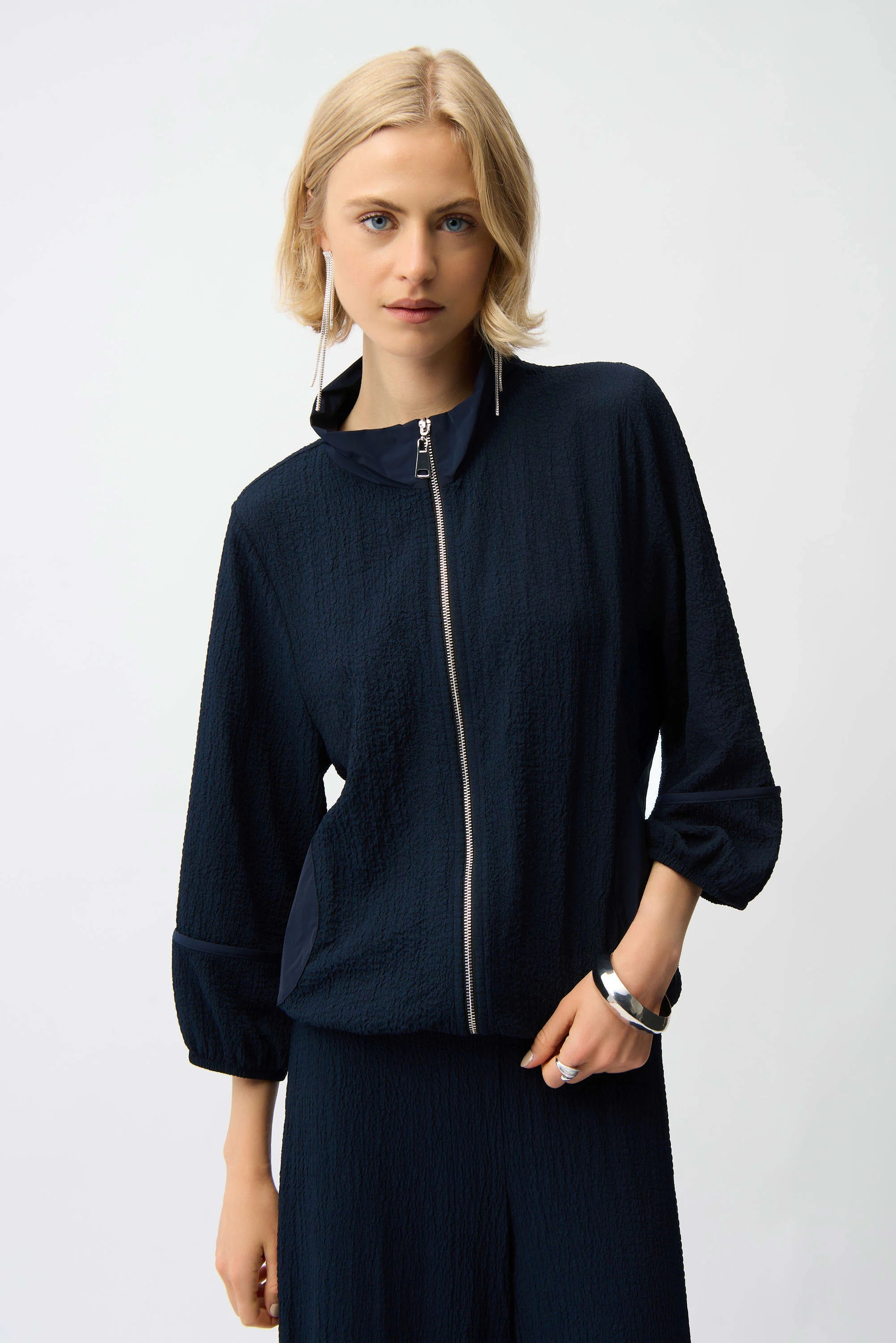 Woman wearing a dark blue jacket with a white background