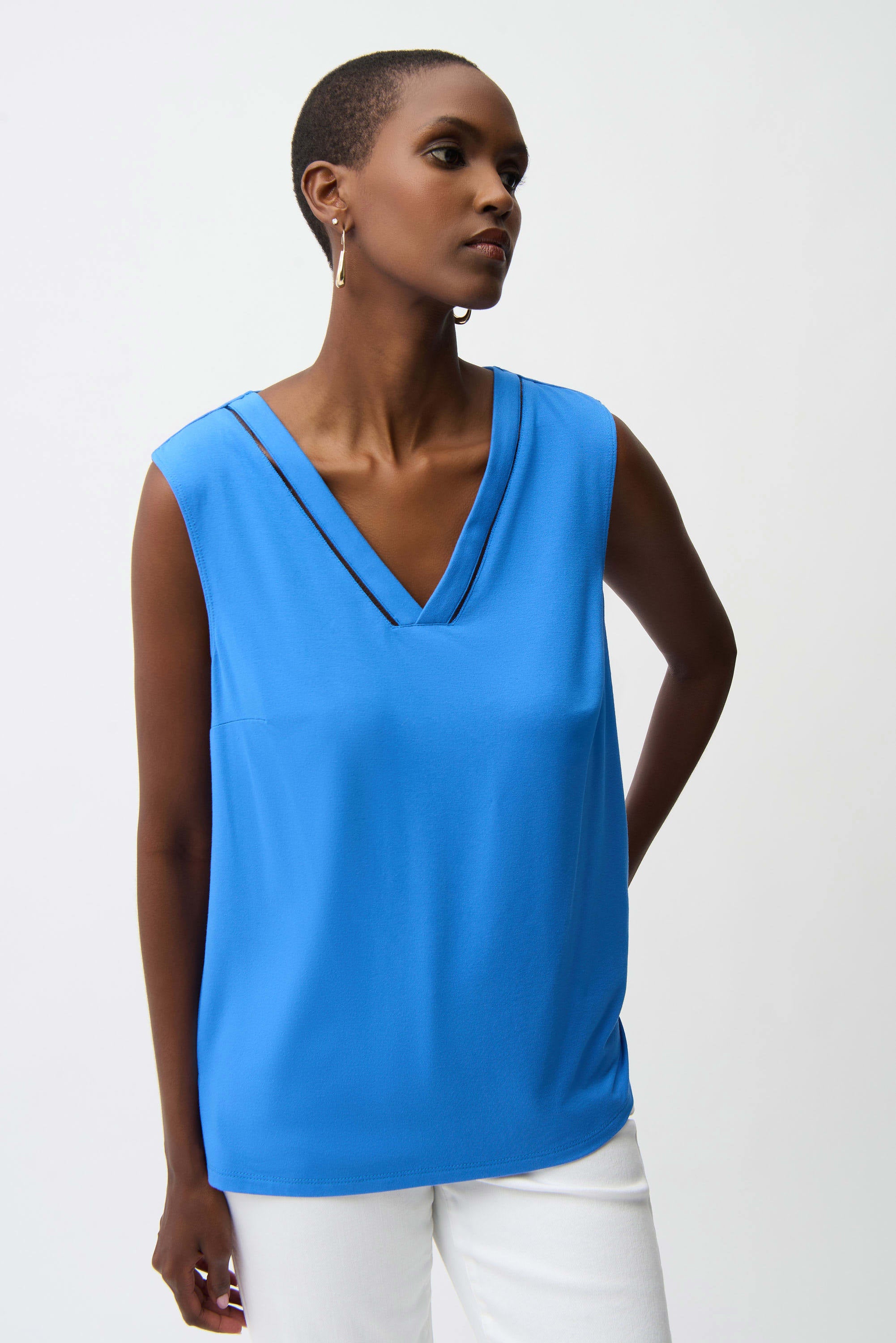 Woman wearing a blue sleeveless top against a white background