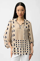 Woman wearing a patterned blouse with long sleeves on a white background