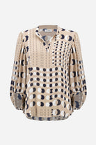 Beige blouse with black and white pattern on a white background