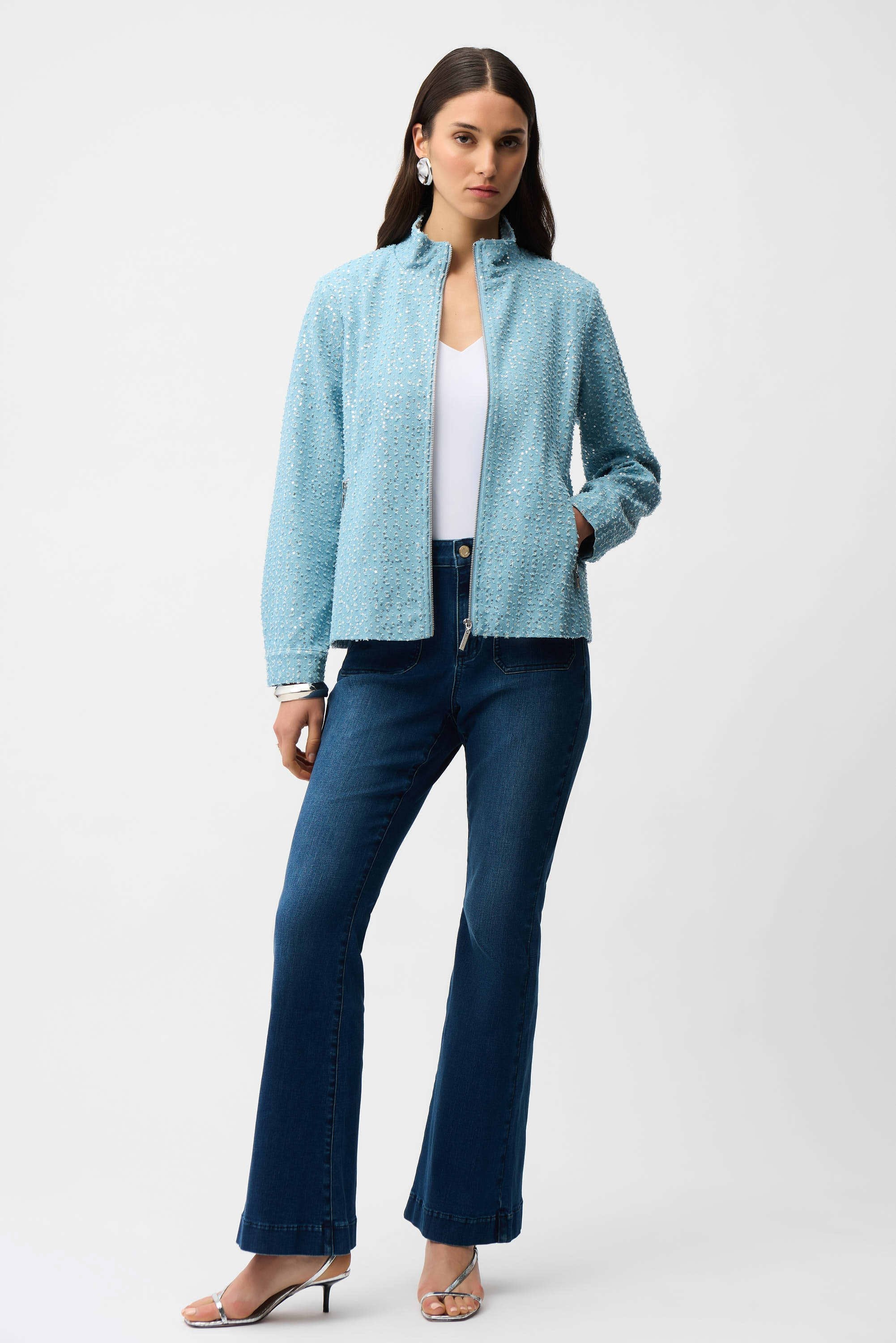 Woman wearing a light blue jacket and dark blue jeans on a white background