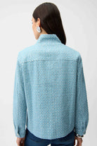 Person wearing a light blue textured shirt on a white background