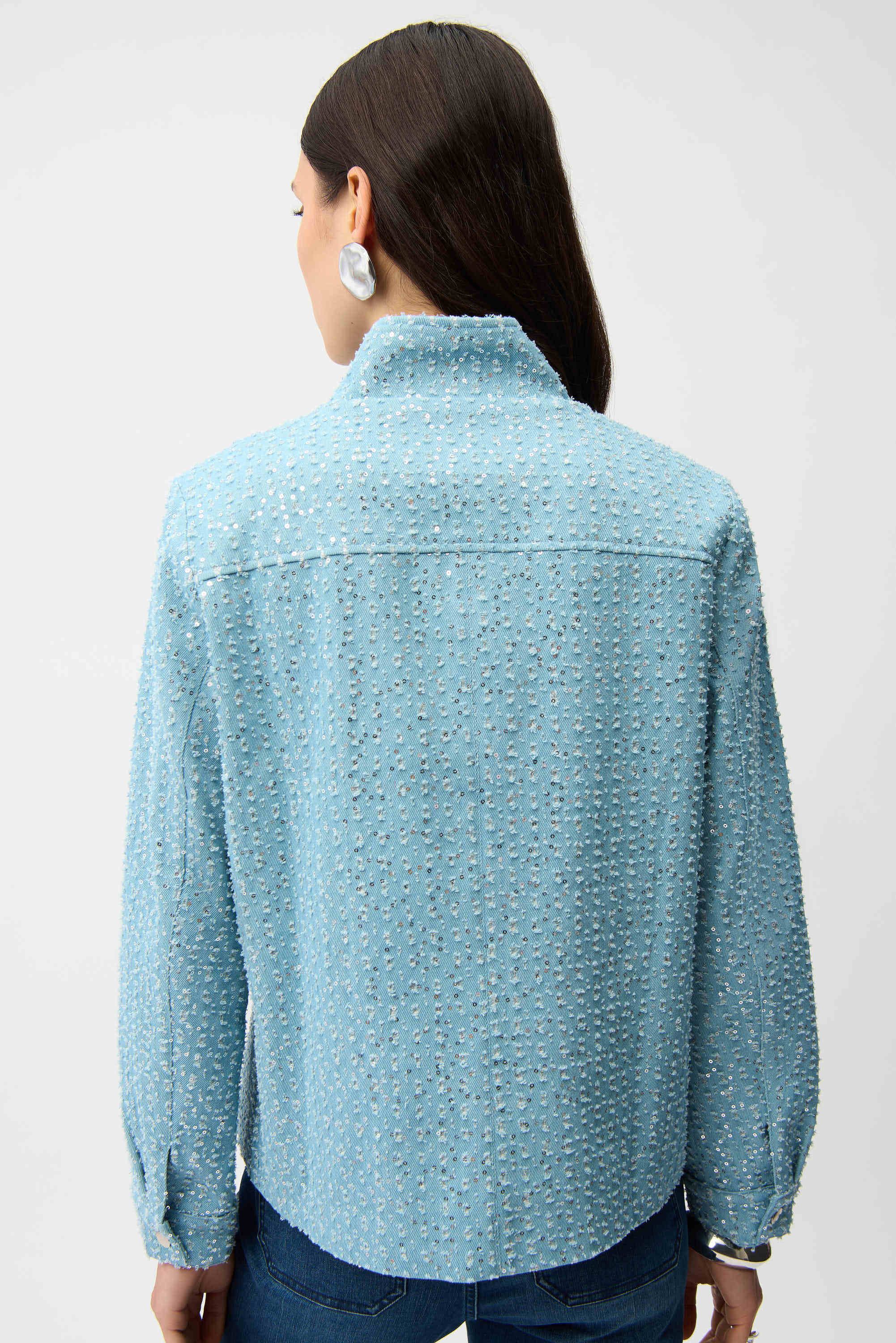Person wearing a light blue textured shirt on a white background