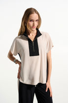 Woman wearing a two-tone blouse with black and beige colors on a white background