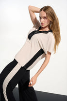 Woman wearing a white and black outfit with a plain background