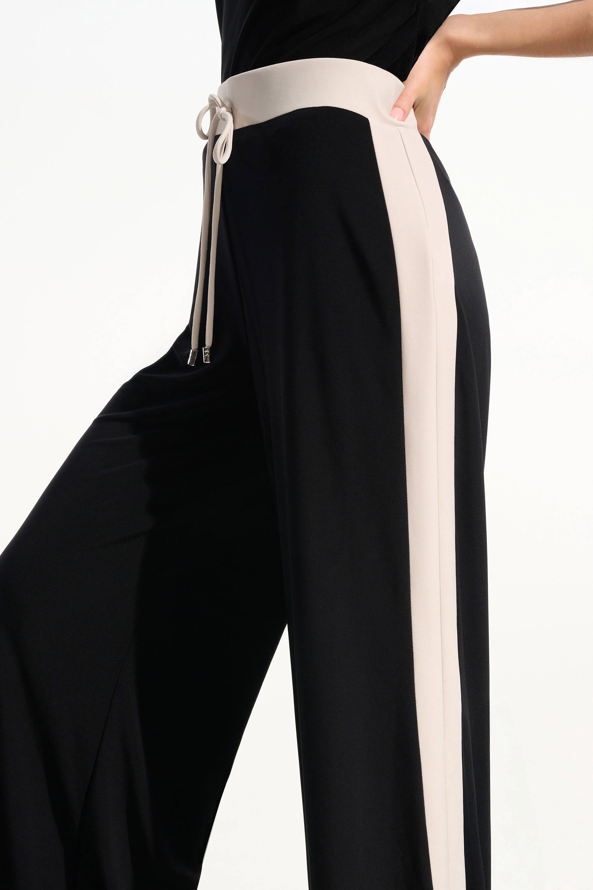 Black pants with a white stripe and drawstring on a white background