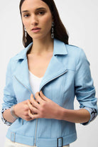 Woman wearing a light blue jacket on a plain background