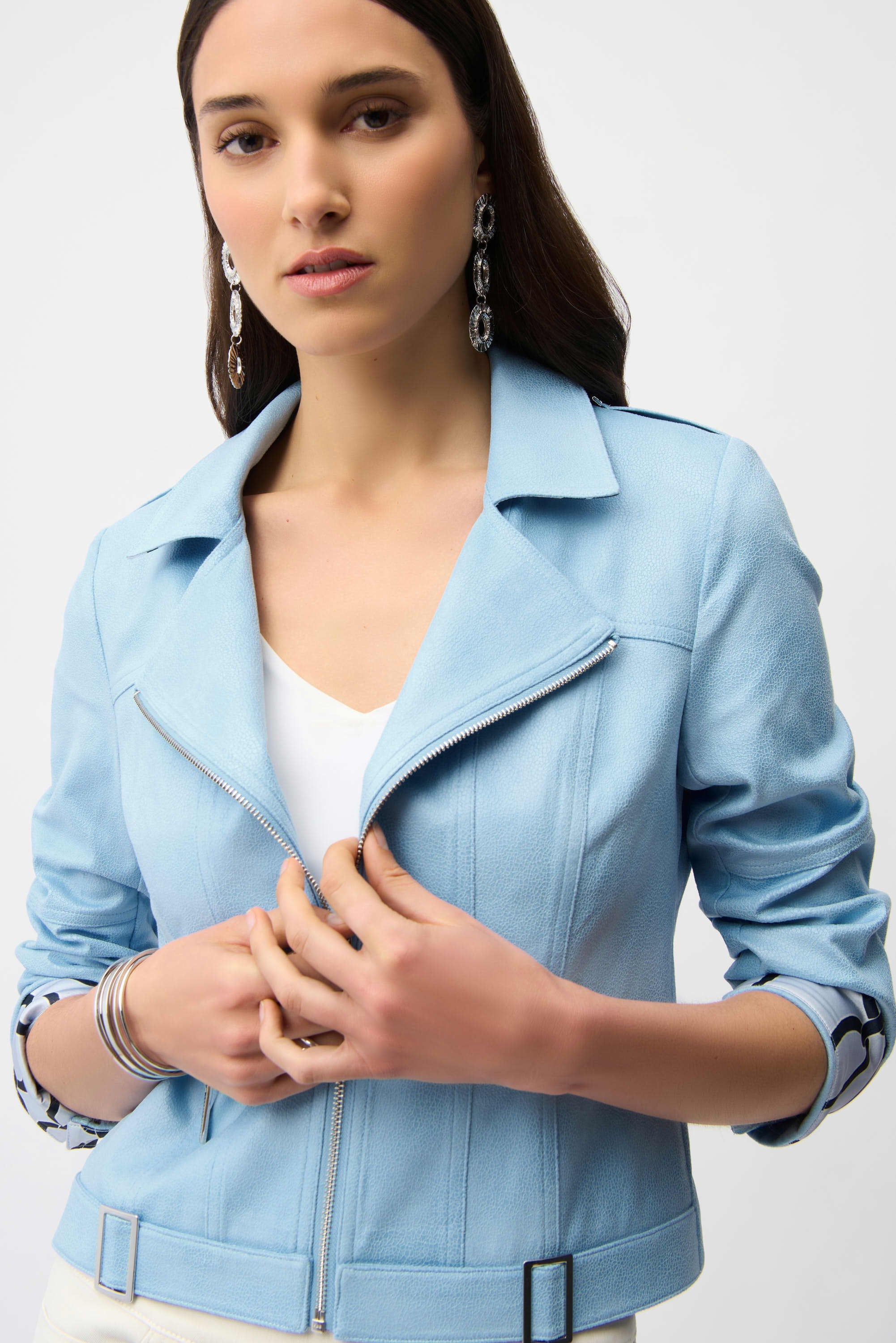 Woman wearing a light blue jacket on a plain background