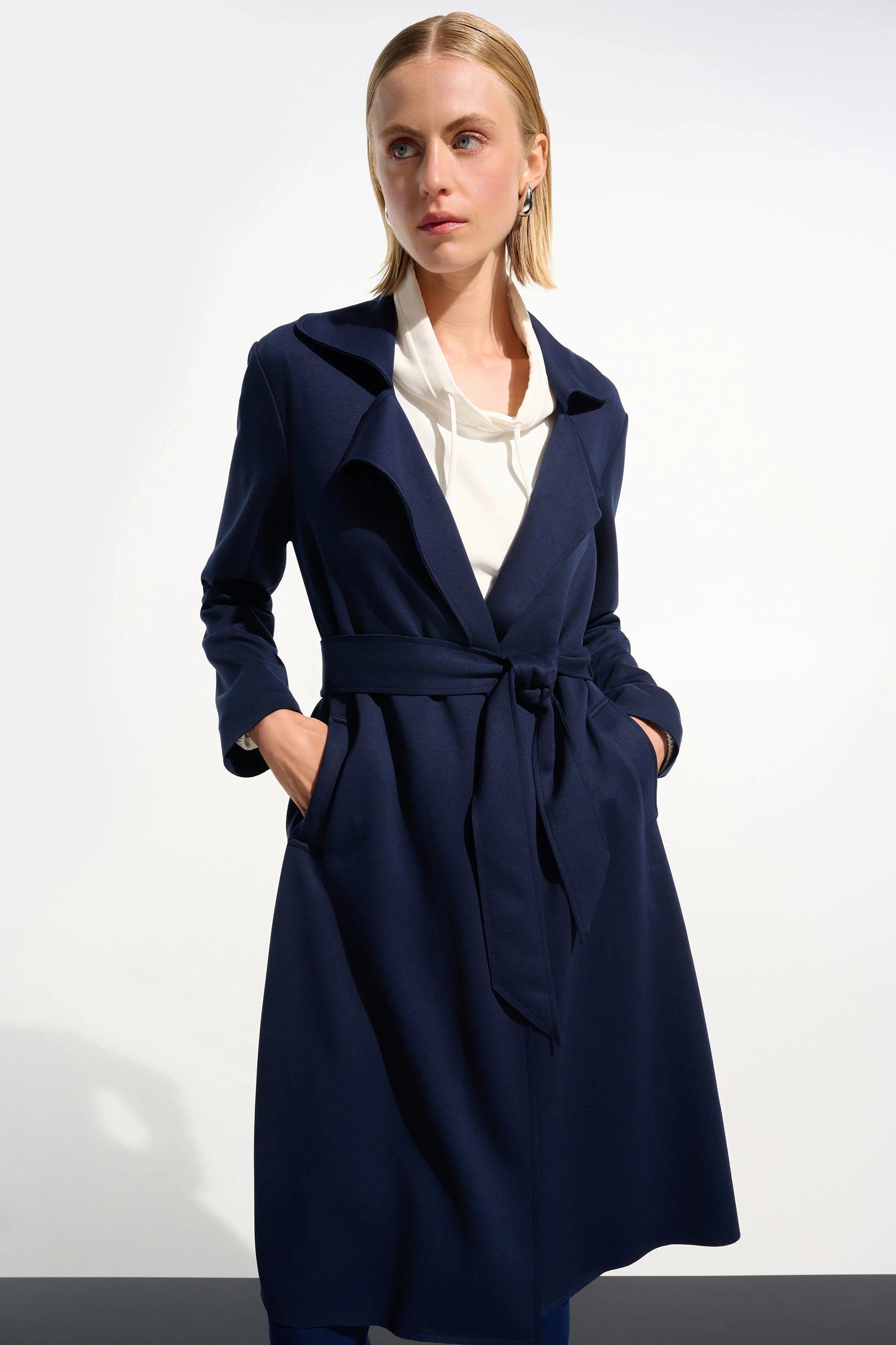 Woman wearing a navy blue coat on a white background