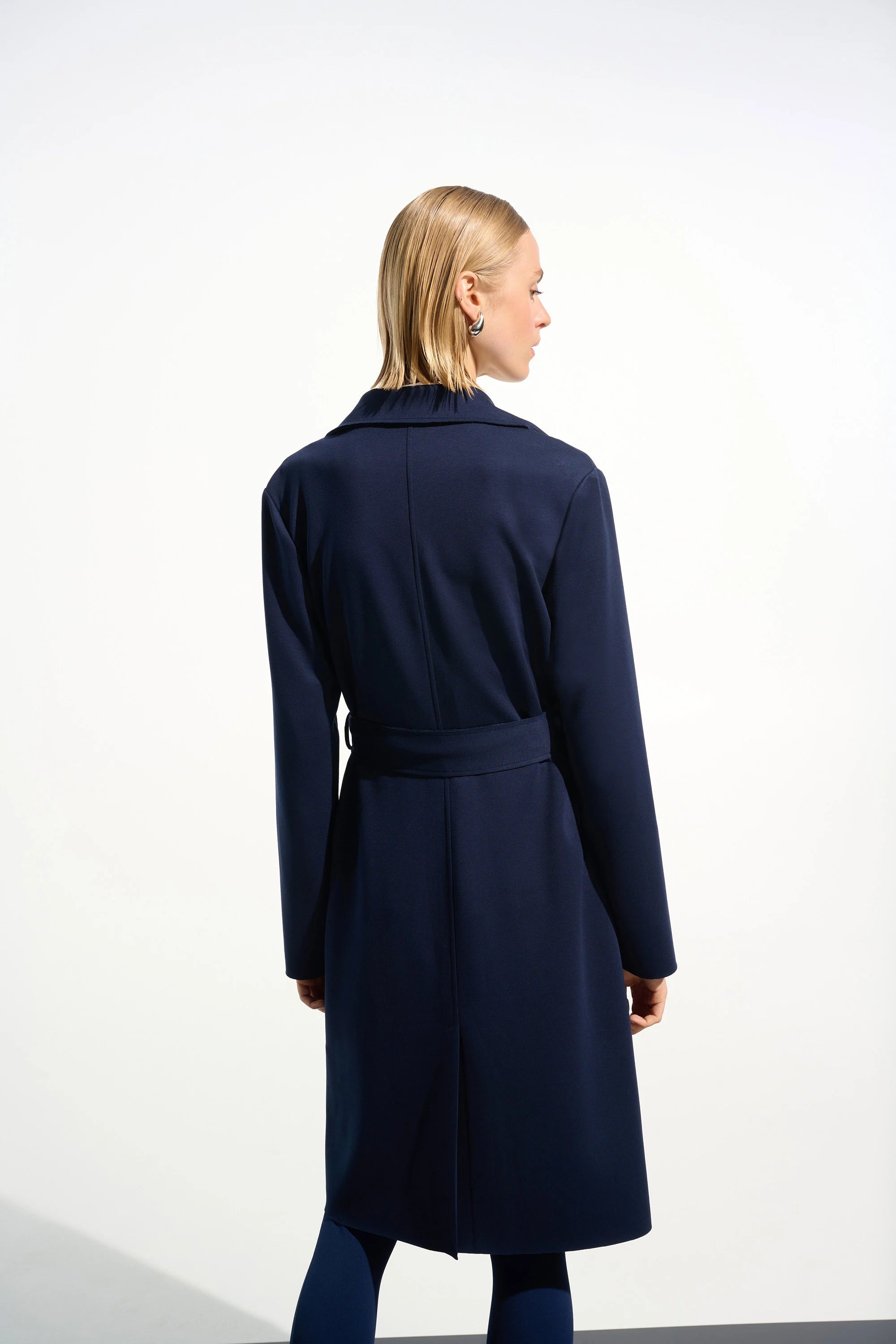 Woman wearing a navy blue coat on a white background