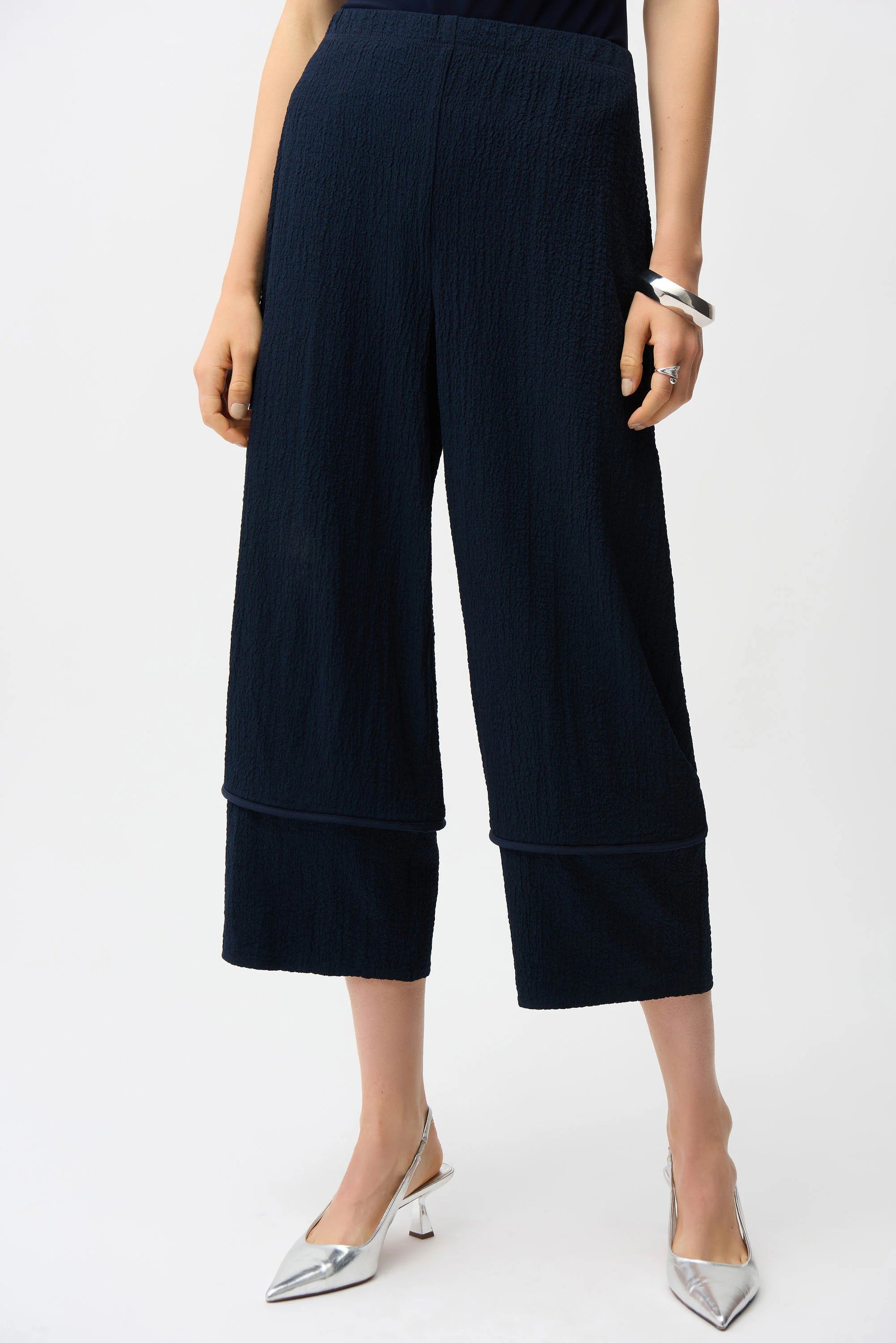 Navy blue wide-leg pants worn by a person on a white background