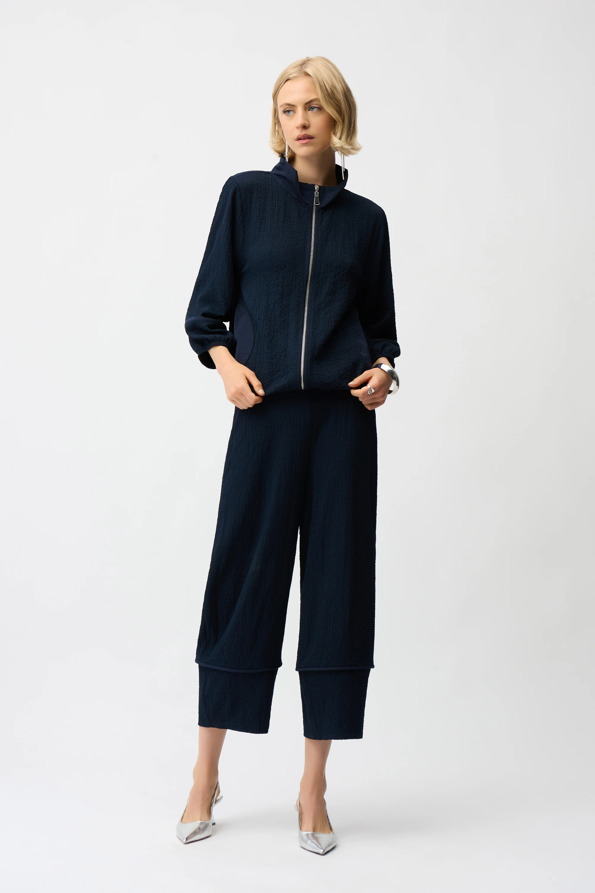 Woman wearing a navy blue outfit on a white background