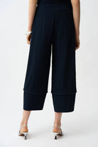Black wide-leg pants worn by a person on a white background