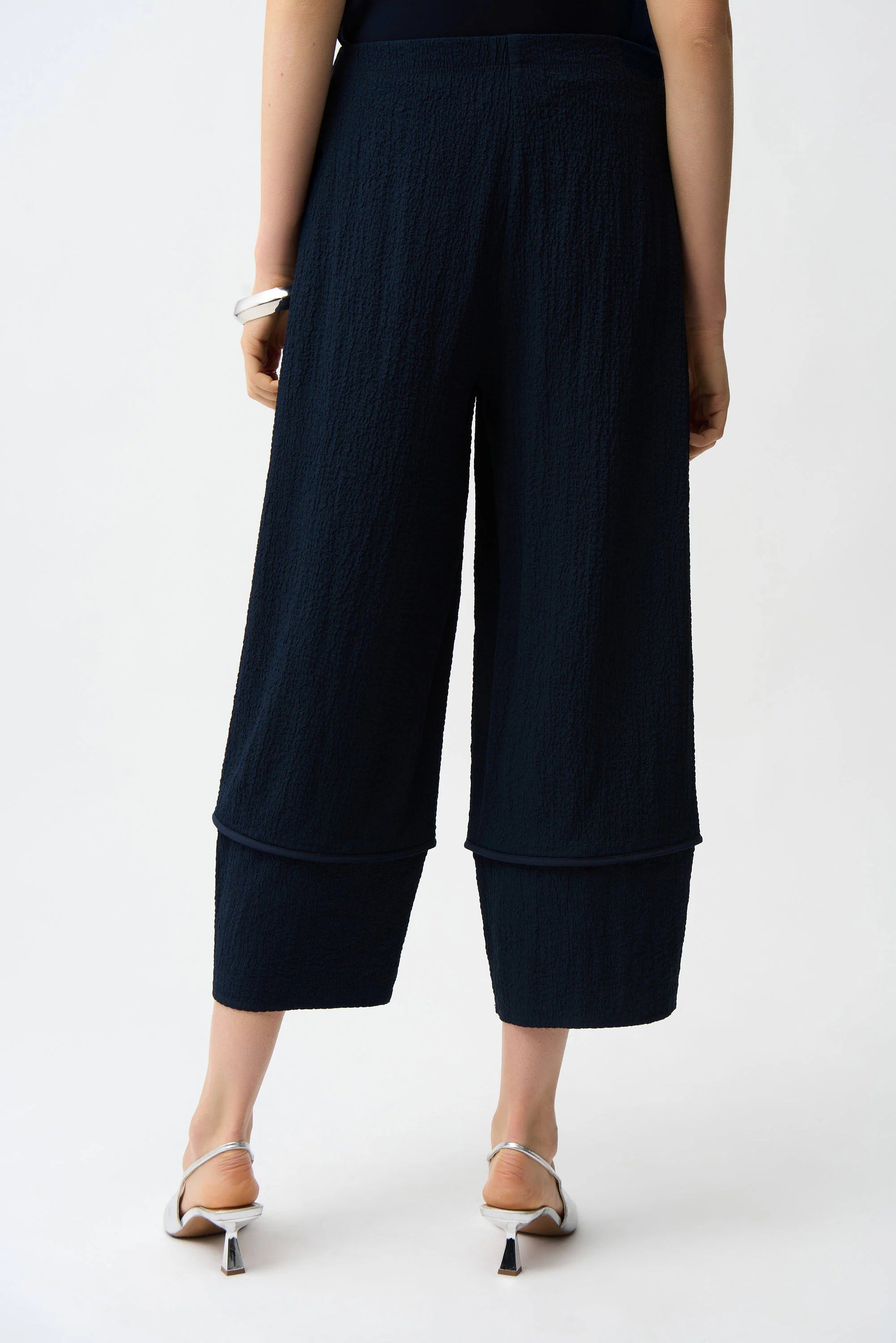 Black wide-leg pants worn by a person on a white background