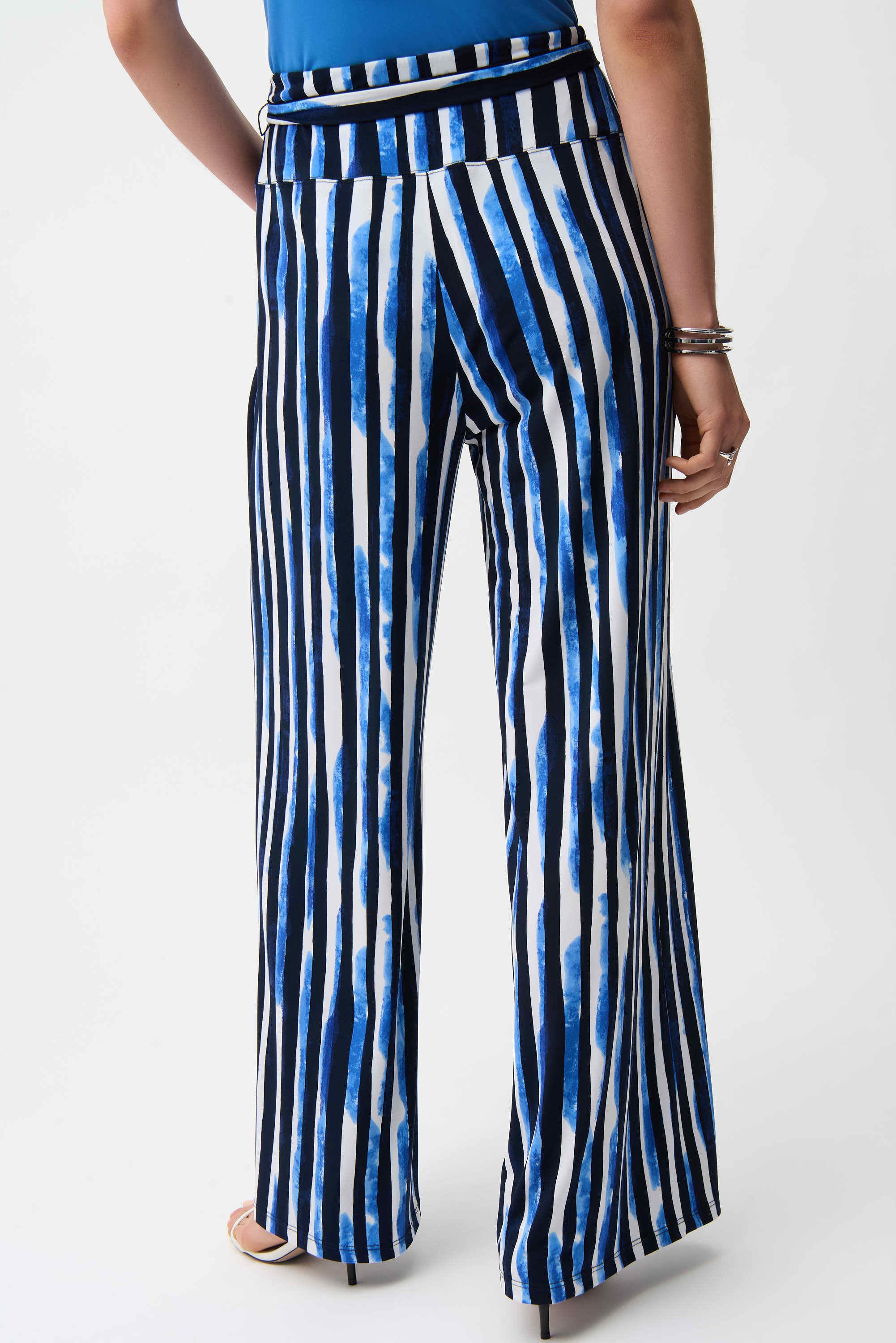 Blue and white striped pants worn by a person on a white background