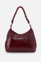 Maroon handbag with braided handle on a white background