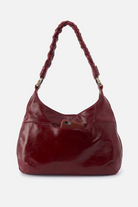 Red leather handbag with braided handle on a white background
