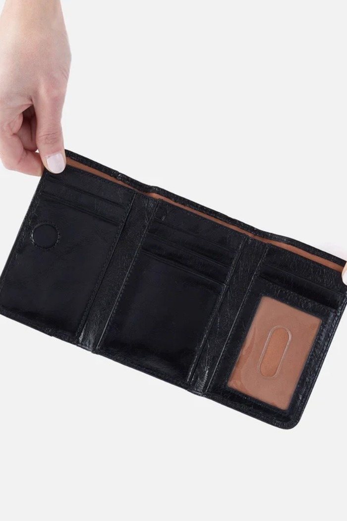 Black leather wallet with a brown interior pocket held open by a hand on a white background