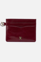 Red leather cardholder with a gold butterfly emblem on a white background