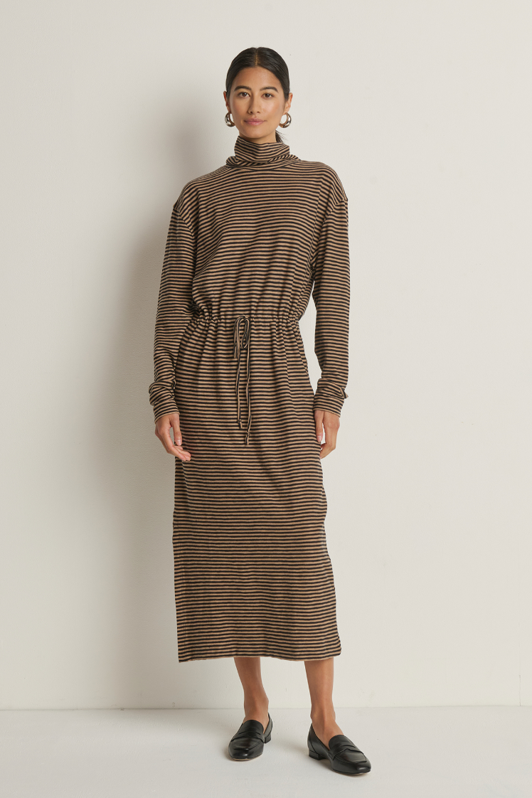 Woman wearing a brown and black striped dress against a white background