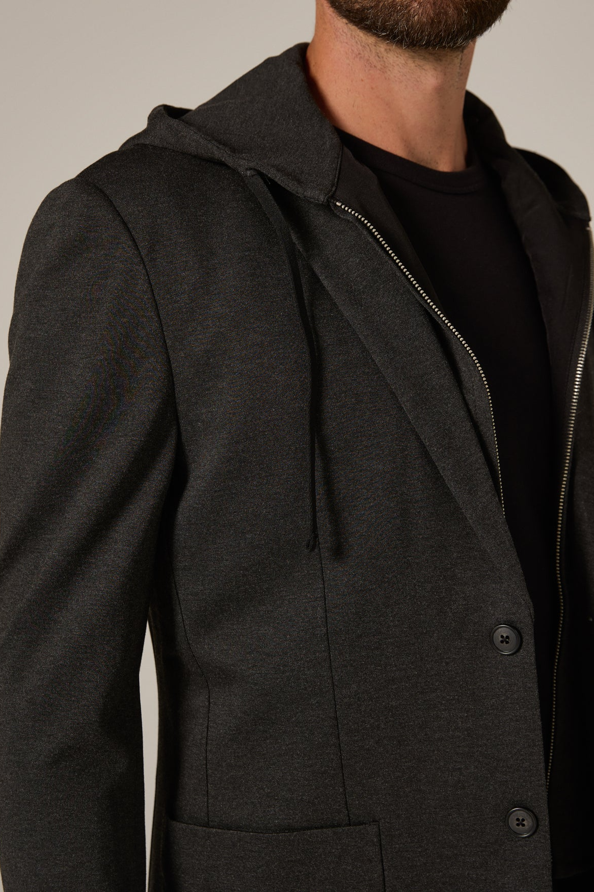 Dark gray hooded coat with a zipper on a neutral background