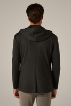 Man wearing a black hooded jacket on a plain background