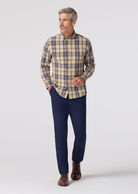 Man wearing a plaid shirt and navy pants on a white background