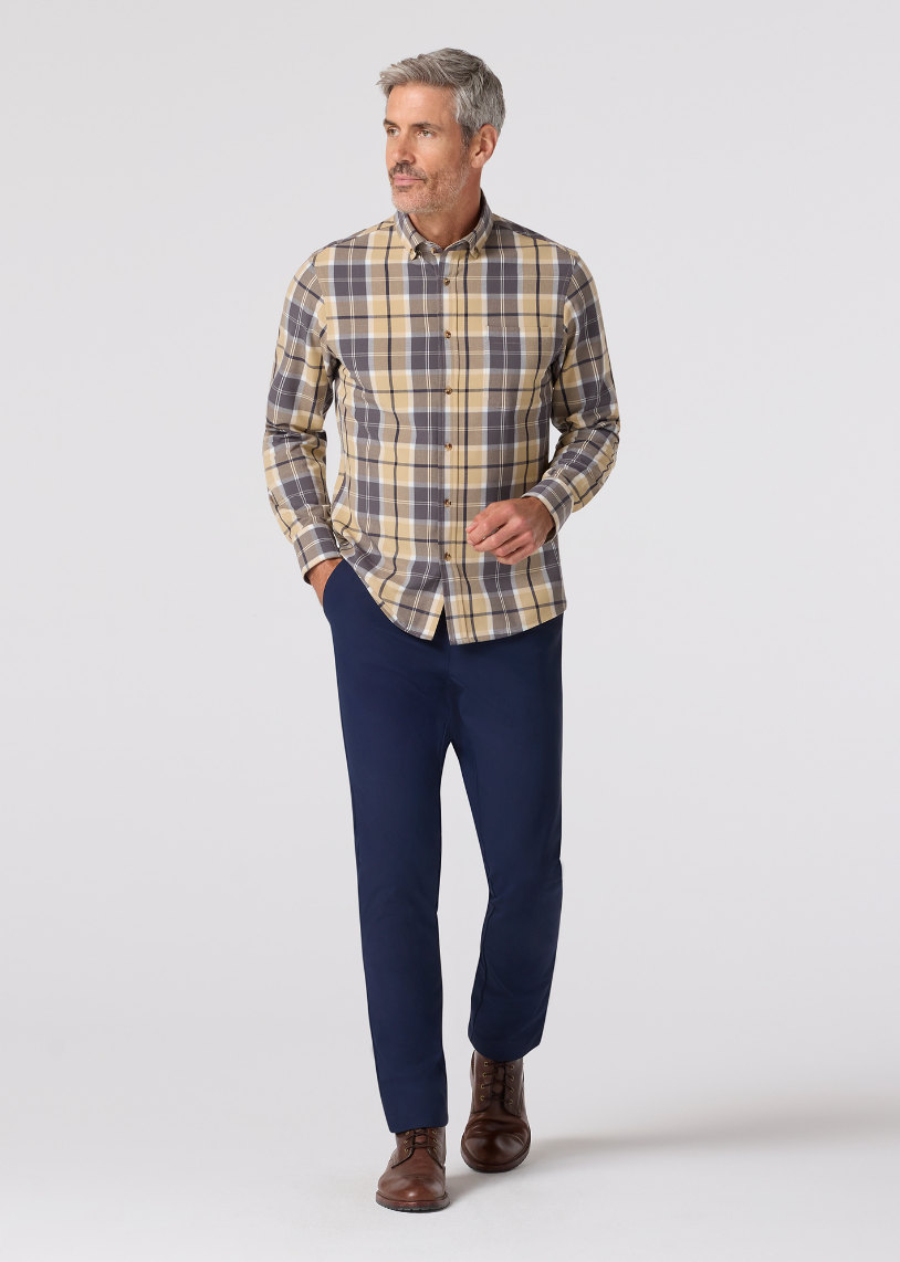 Man wearing a plaid shirt and navy pants on a white background