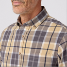 Man wearing a plaid shirt with a neutral background