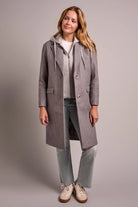 Woman wearing a gray coat on a plain background