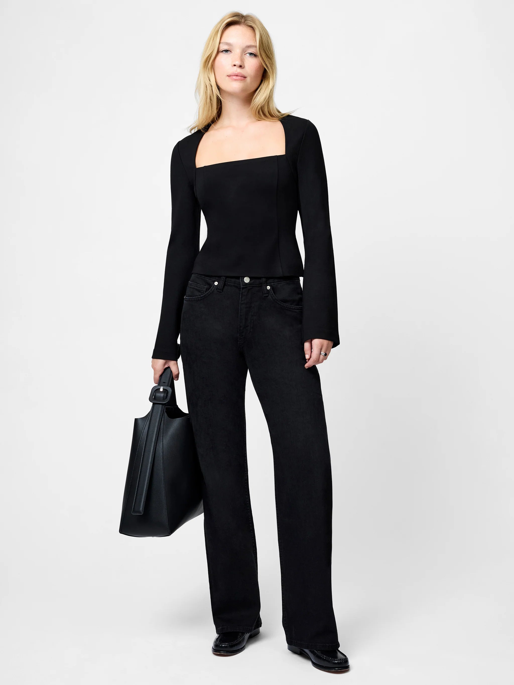 Woman wearing a black outfit with a plain background