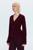 Woman wearing a burgundy suit against a light gray background