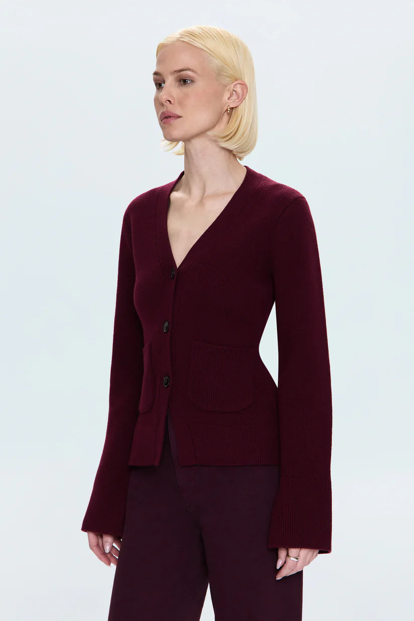 Woman wearing a burgundy suit against a light gray background