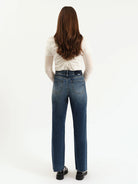 Person wearing blue jeans and a white shirt on a white background