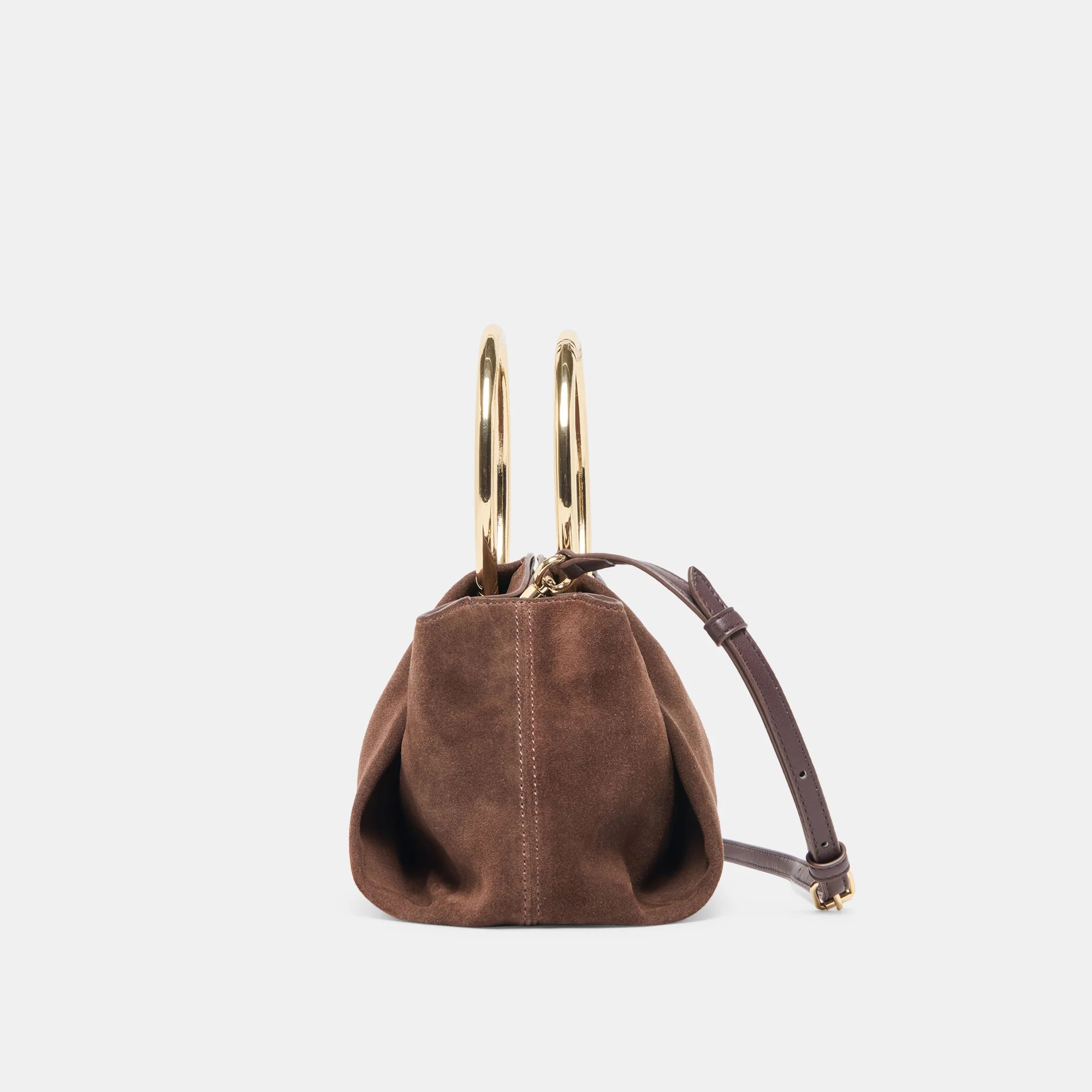 Brown suede handbag with gold handles on a light gray background