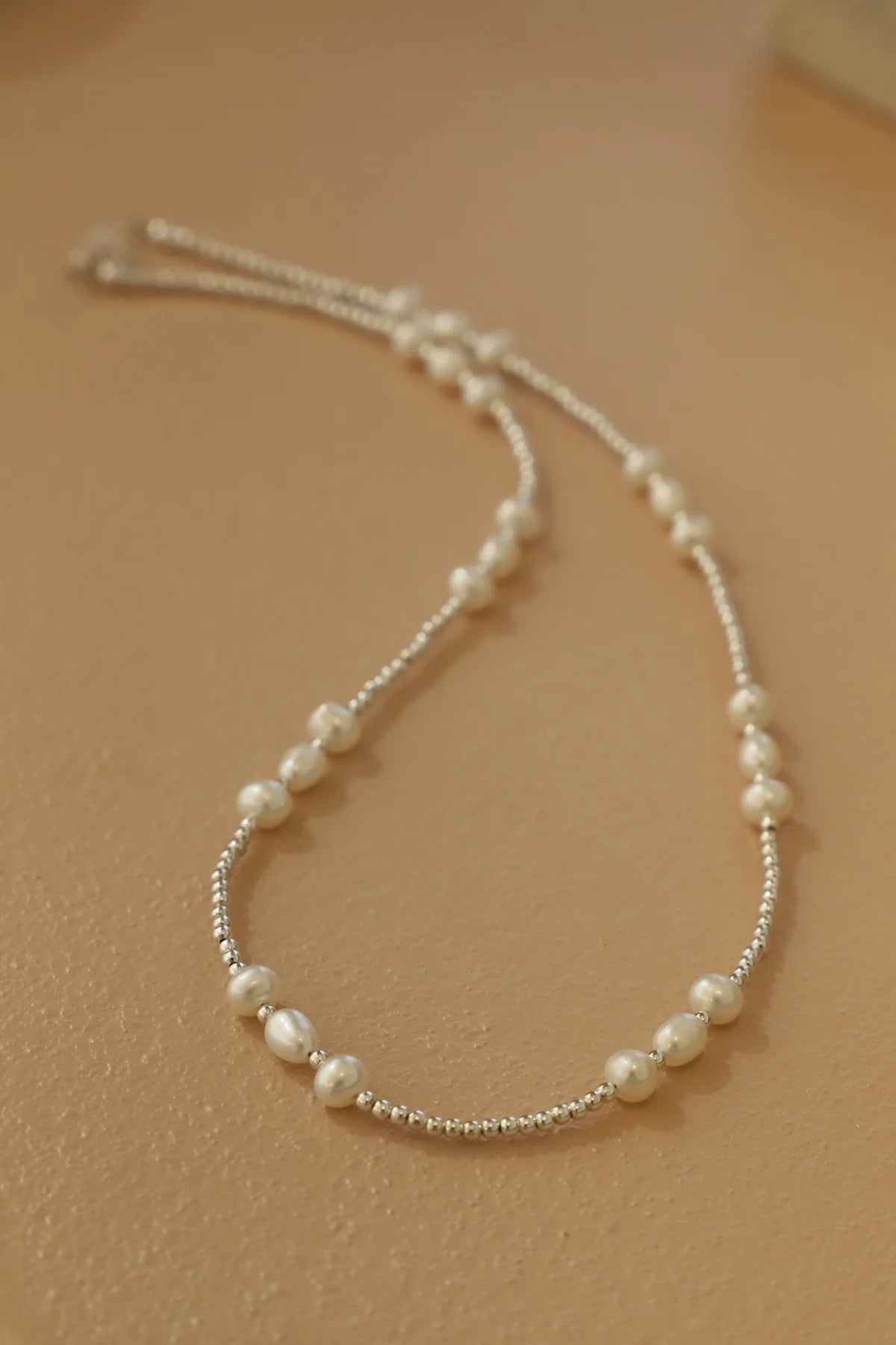 Pearl necklace on a beige background
