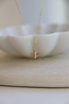 Gold bee necklace on a white background