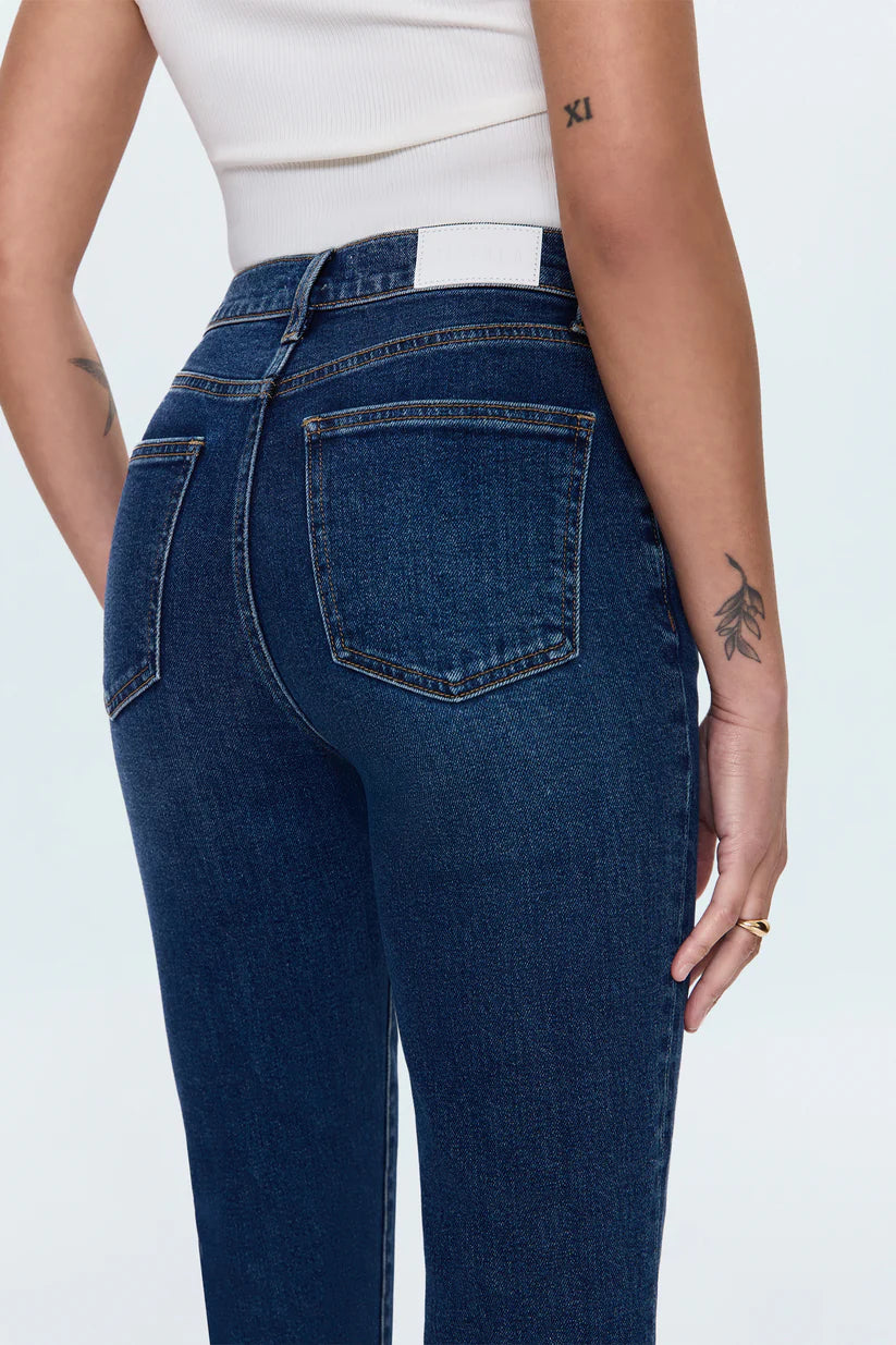Person wearing dark blue jeans on a white background