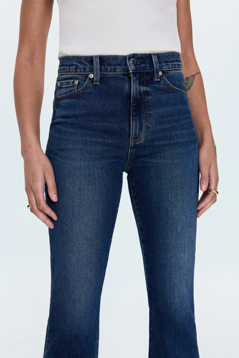 Person wearing dark blue jeans on a white background