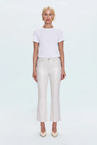 Person wearing a white t-shirt and light-colored pants on a white background